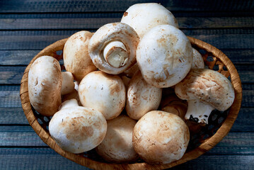basket of fresh natural mushrooms on a wooden table.