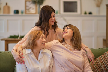 middle aged mother grown up adult daughter and grandmother, women from different generations together at home, love warm relationships and affectionate concept
