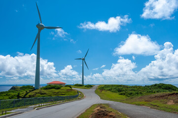 Wind turbines on the Yonaguni island road with a nice vegetation and blue sky.