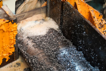 Industrial band saw, band saw cutting tool steel bar by automatic feed, coolant in yellow scene,...