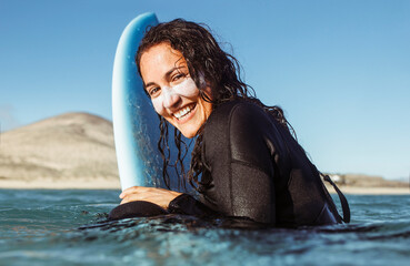 Woman surfing in the sea with a yellow surfboard - 410913816