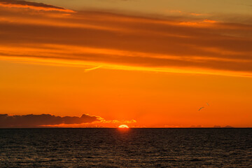 Fototapeta na wymiar Colorful tropical sunset above line of the horizon