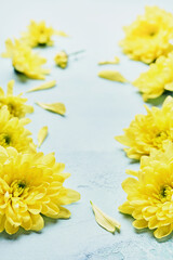 Spring yellow flowers and Easter decorations on blue background. Mock up. Top view.
