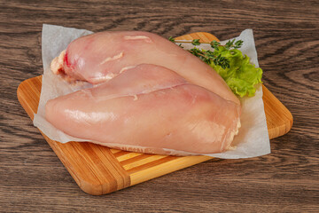 Raw chicken breast over board