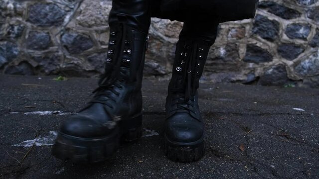 High women's boots with laces with thick soles. The woman is trampled on the asphalt in anticipation.