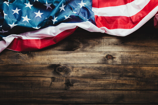 July 4, U.S. Independence Day image with U.S. flag on wooden background. View from above. Flat floor. Copy space.