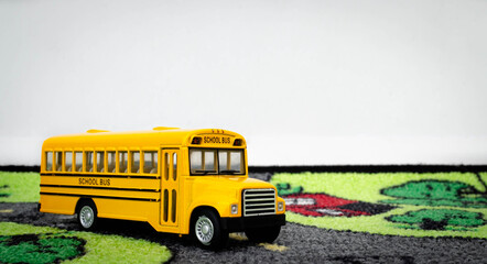 A toy school bus on a children's play rug
