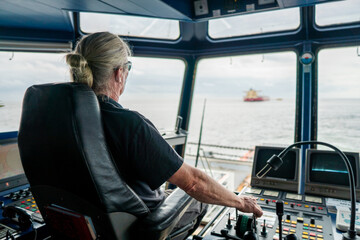 Captain of deck Officer on bridge of vessel or ship during navigaton watch at sea . He is...