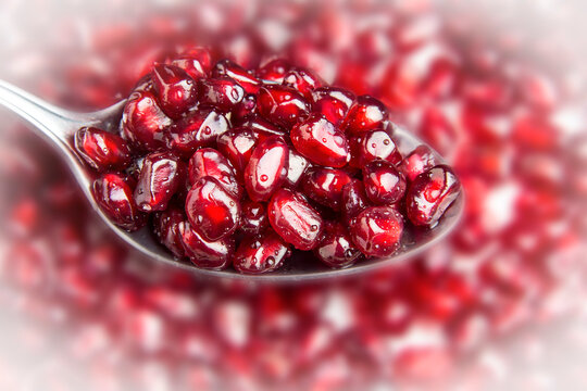 A tablespoon with pomegranate berries. Delicious berries.