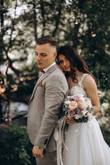 Walking the bride and groom outdoors. Beautiful summer photo session in nature.