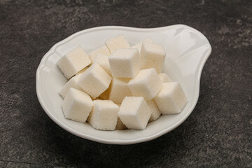 Fototapeta na wymiar Refined white sugar cubs in the bowl