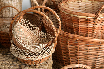 Many different wicker baskets made of natural material as background, closeup