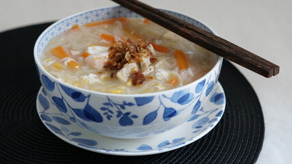 Vietnamese noodles in flower-painted bowl with chopsticks on top