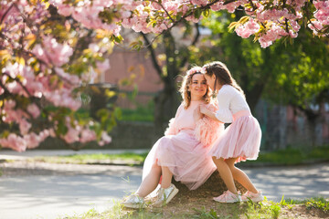 mom and daughter are standing next to a tender plant