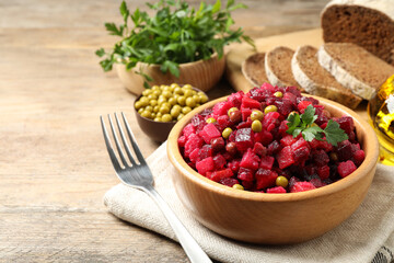 Traditional Russian salad vinaigrette served on wooden table. Space for text
