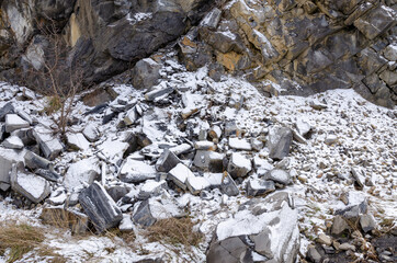 snow covered rocks along the side of a road