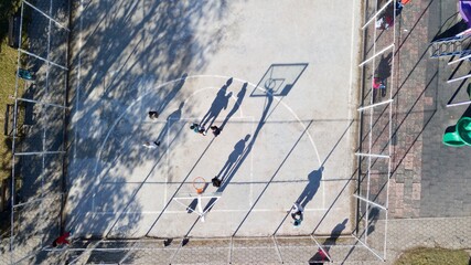 aerial view of street basketball court and children playground. kids are playing football at the...