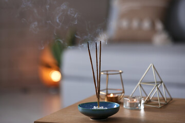 Incense sticks smoldering on table indoors, space for text