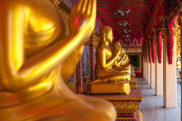The Gold praying Buddha statue at Wat Luang Pho Ophasi temple in Bang mod district, Bangkok Thailand