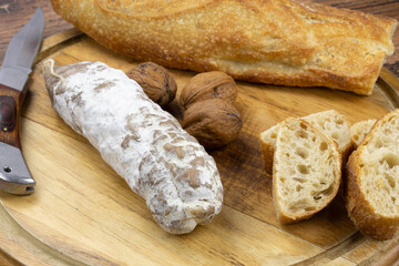 saucisson sec aux noix et pain sur une planche à découper