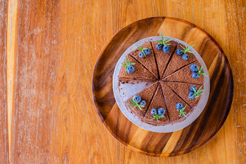 chocolate with blueberry cake on a wooden plate