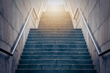 Fototapeta na wymiar Concrete stairs leading up towards light. Concept of hope and bright future