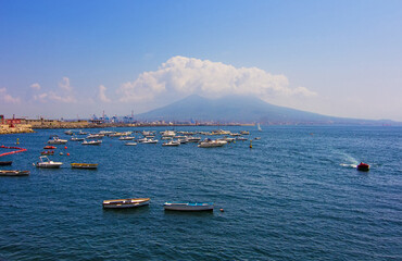 Mount Vesuvius partially covered by fog. View from embankment of Naples. Seascape of Napoli city with view of the port in the Gulf of Naples and Tyrrhenian sea on the background. Campania, Italy.