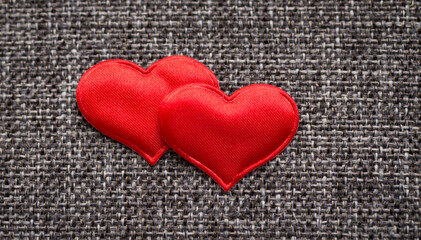Red hearts on gray textile background. Close-up macro