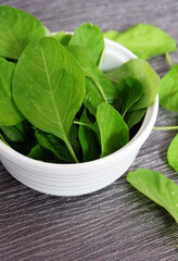 Fresh and raw spinach on a white bowl.
