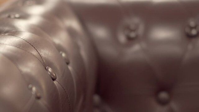 Detail of classic brown leather sofa with button pattern