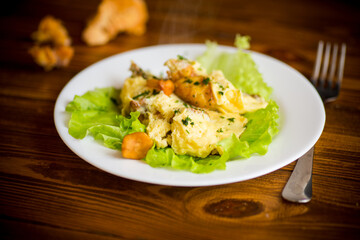 fried omelet with forest mushrooms chanterelles, on table