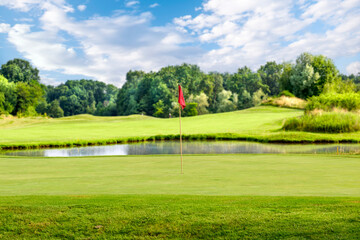 Golf course with a red flag on a summer day