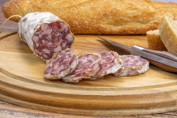 saucisson sec et baguette de pain sur une planche à découper