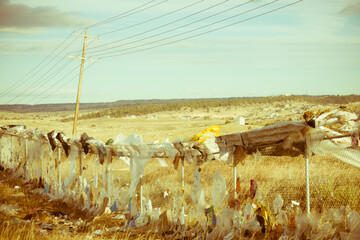 Trash against fence in a landfill. Environment and littering