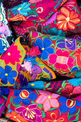 Close up of handmade traditional Mexican women's purses, multi-color floral design, culture, and craft tradition. Vertical screen orientation