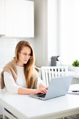 Working home online. Photo of a woman in front of laptop monotor in home interior.