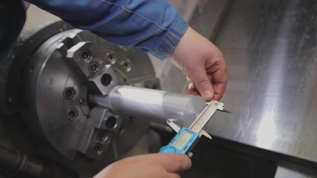 Taking measurements with a caliper. Caliper, Caliper Measurements. A man makes measurements with a caliper.