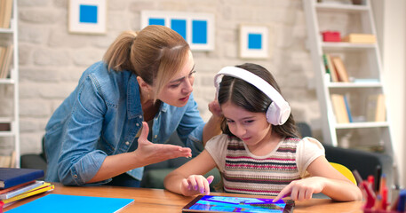 The mother yells at her daughter who does not do her homework and is constantly playing games on...
