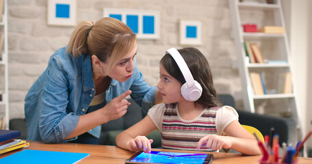 The mother yells at her daughter who does not do her homework and is constantly playing games on...