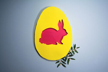 Design for the holiday Happy Easter. Paper art. Egg and rabbit shape cut from paper. Framed with natural plants. For your Easter background. Copy space and flat lay style
