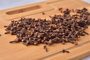 Aromatic cloves magnified on a wooden kitchen board, spices and aromas. Large depth of field.