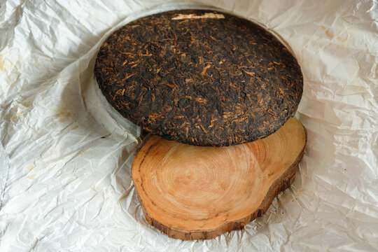 Pressed Chinese puerh tea and cross-section a tree trunk. Tea wrapping paper. Copy space. Mockup.