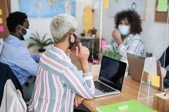 Multiracial people working in office with safety measures for coronavirus outbreak - Protective face mask and dividers for social distance