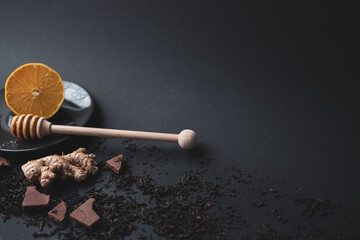 tea ceremony . lemon tea honey teapot on black background. copy space.
