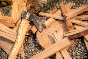 Preparation of wood to light a fire to cook food on grill outdoor. Still-life of an ax and pieces of firewood. Fuel material for stoves and fireplaces. Camping, barbecue, outdoors, recreation, concept