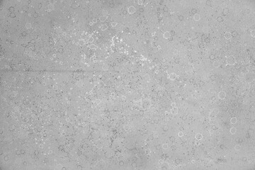 Gray loose acrylic paint texture with white and dark stains. Background, substrate.