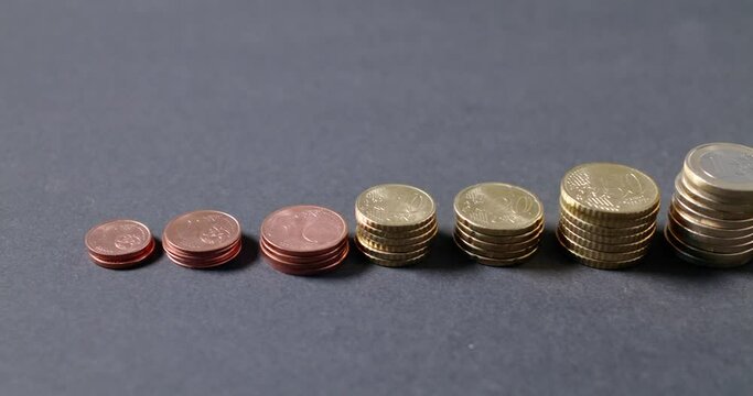 Panning from 2 Euro Pile to 1 Cent Coins. Euro Coins isolated on Grey Background
