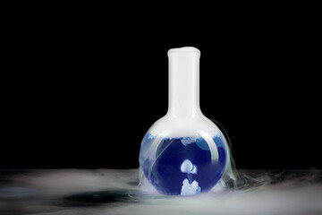 Boiling flask with blue water and dry ice. Boiling chemical experiment. Chemical reaction. Chemist demonstration.