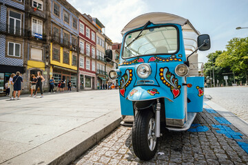 Fototapeta na wymiar Blue tricycle waiting for tourist on the street of Porto, Portugal