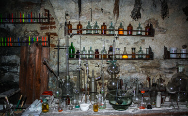 Old scary laboratory mining tools & measuring devices. Bottles in old pharmacy laboratory. Old vintage mini laboratory. Medieval drugs potion on dirty shelf, apothecary cabinet in pharmacy lab or shop - obrazy, fototapety, plakaty